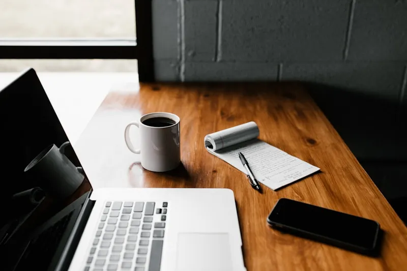 A laptop and notebook on a desk — the tools for crafting a great follow-up